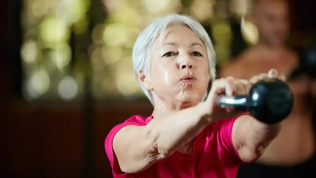 Toning Arms After 60: Empowering Womens Fitness Through Effective Weight Training 1 Older woman doing weight training Gloucestershire to help her strength and longevity